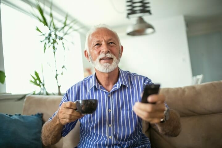 A senior with a TV remote