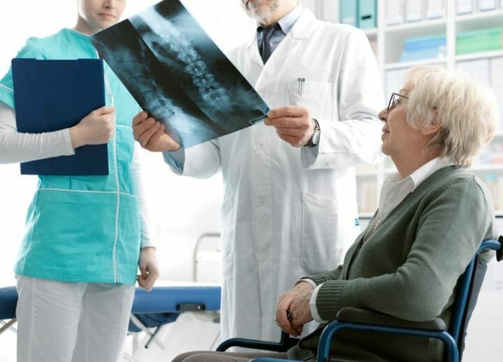 Doctor and nurse looking at Spinal Xray of a senior patient
