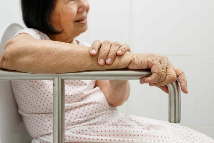 Elder Resting Her Arm in Handrail