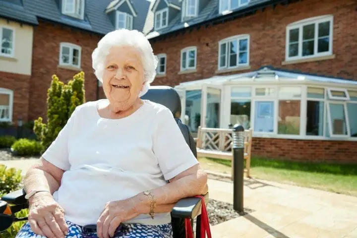 senior woman sitting outside in her electric wheelchair