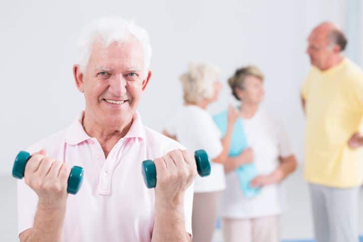 Elderly man holding dumbbells