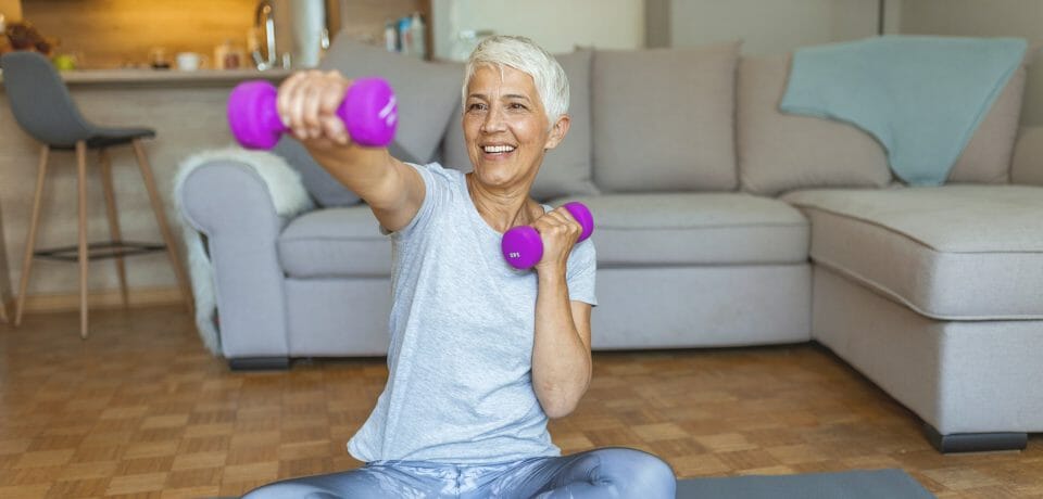 Elderly woman exercising with dumbells