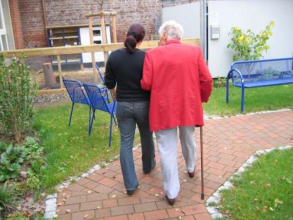 Elderly woman walking with her caregiver