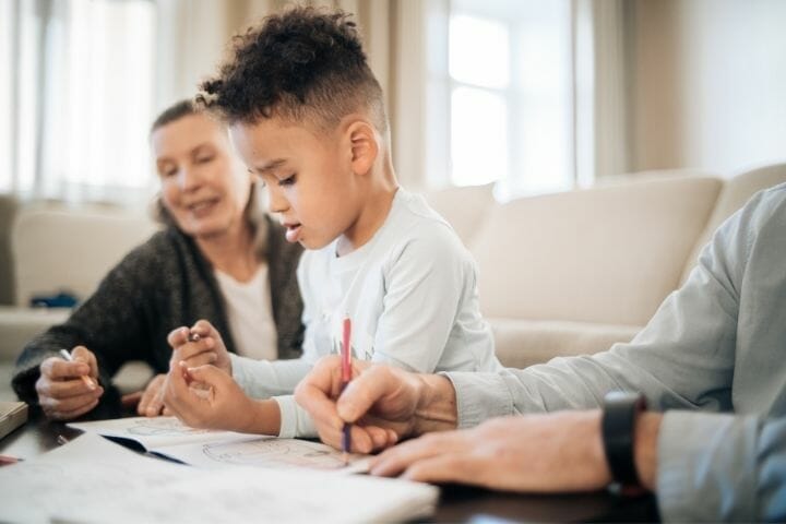 kid drawing with his grandparents