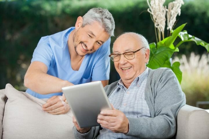 Caregiver and elderly patient using digital tablet
