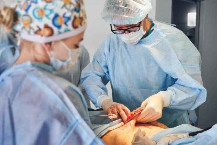 Surgeons performing tummy tuck surgery